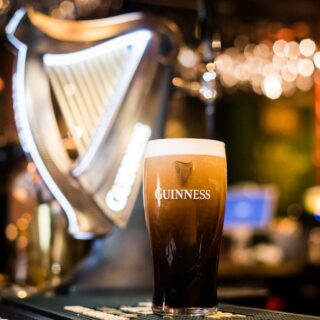 Close up image of a pint of Guinness beer on a pub's counter